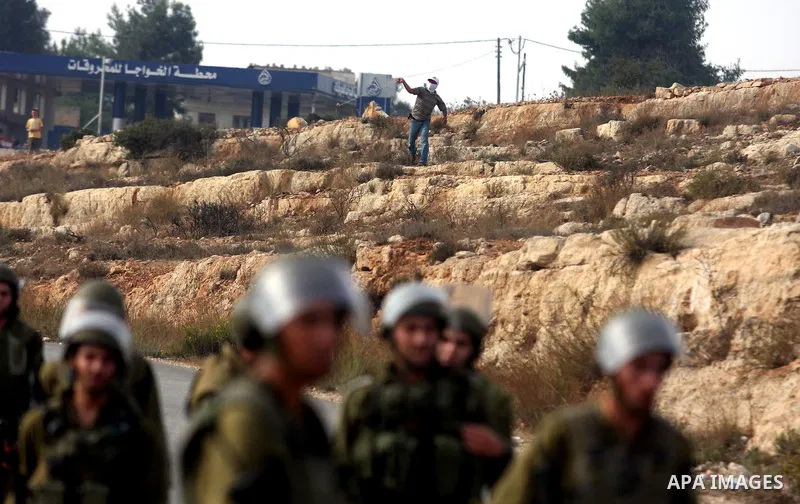 Palestinians argue with Israeli soldiers during a protest against the expansion of the nearby Jewish settlement of Halamish, in the West Bank village of Nabi Saleh near Ramallah, Friday, Nov. 2, 2012. Photo by Issam Rima...