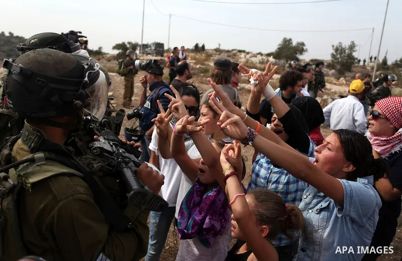 Palestinian girls scuffle with Israeli soldiers during a protest against the expansion of the nearby Jewish settlement of Halamish, in the West Bank village of Nabi Saleh near Ramallah, Friday, Nov 2, 2012. Photo by Issa...