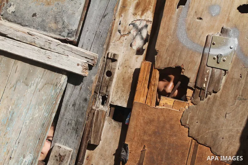 Palestinian children peer through a wooden door at the Shati Palestinian refugee camp in Gaza City on November 3, 2012. The issue of refugees is one of the thorniest elements of the Palestinian-Israeli conflict, with the...