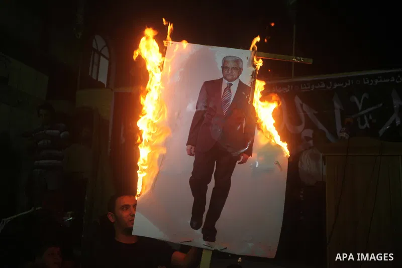 A Hamas supporter burns a poster depicting Palestinian President Mahmoud Abbas during a protest in Jabalya in the northern Gaza Strip November 3, 2012. Abbas made a rare if symbolic concession to Israel on Thursday, sayi...