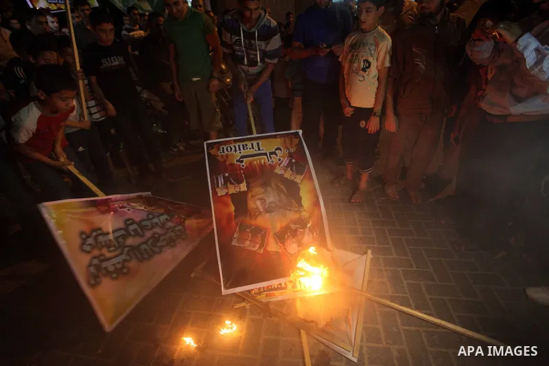 A Hamas supporter burns a poster depicting Palestinian President Mahmoud Abbas during a protest in Jabalya in the northern Gaza Strip November 3, 2012. Abbas made a rare if symbolic concession to Israel on Thursday, sayi...