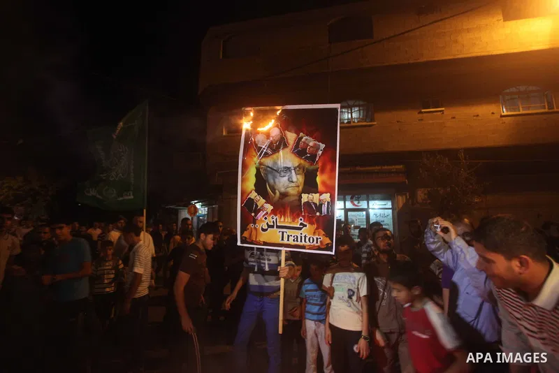 A Hamas supporter burns a poster depicting Palestinian President Mahmoud Abbas during a protest in Jabalya in the northern Gaza Strip November 3, 2012. Abbas made a rare if symbolic concession to Israel on Thursday, sayi...