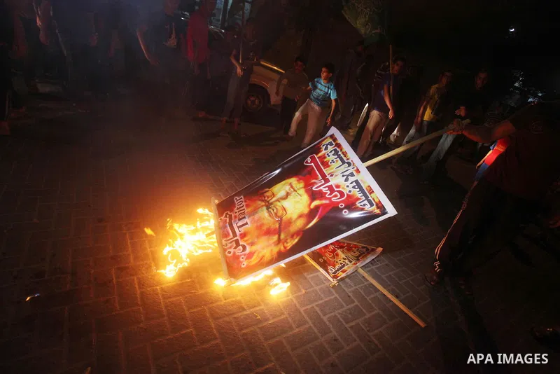 A Hamas supporter burns a poster depicting Palestinian President Mahmoud Abbas during a protest in Jabalya in the northern Gaza Strip November 3, 2012. Abbas made a rare if symbolic concession to Israel on Thursday, sayi...