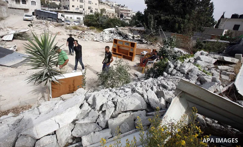 Palestinians carry furniture from the rubble of their house after it was demolished by Jerusalem municipality workers in the east Jerusalem neighborhood of al-Tur on November 5, 2012. Israel's policy of house demolitions...