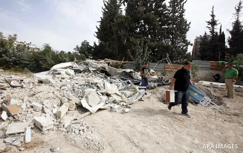 Palestinians carry furniture from the rubble of their house after it was demolished by Jerusalem municipality workers in the east Jerusalem neighborhood of al-Tur on November 5, 2012. Israel's policy of house demolitions...