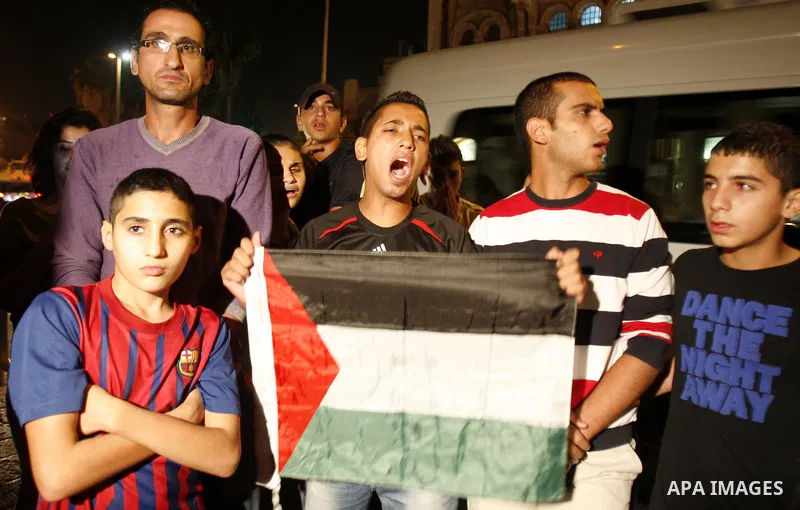 Palestinians protesters hold national flags during a demonstration against Palestinian Authority President Mahmud Abbas, in Bab al-Amoud in Jerusalem's old city on November 5, 2012. Protestors gathered to express their a...