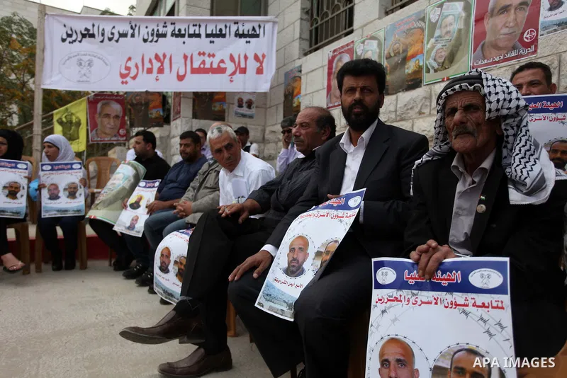 Palestinians hold pictures of prisoners held in Israeli jails during a sit-in outside the Red Crescent offices near the West Bank city of Ramallah on Nov. 6, 2012. Photo by Issam Rimawi