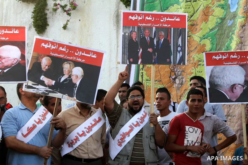 El-Ahrar party supporters carry placards and posters of Palestinian President Mahmoud Abbas with Israeli leaders during a demonstration in Gaza city on November 6, 2012. Protestors gathered to express their anger towards...