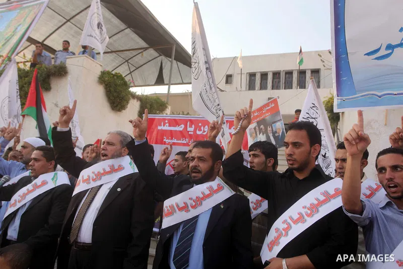 El-Ahrar party supporters carry placards and posters of Palestinian President Mahmoud Abbas with Israeli leaders during a demonstration in Gaza city on November 6, 2012. Protestors gathered to express their anger towards...