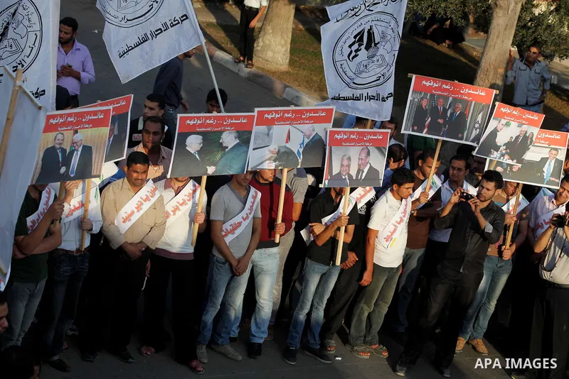 El-Ahrar party supporters carry placards and posters of Palestinian President Mahmoud Abbas with Israeli leaders during a demonstration in Gaza city on November 6, 2012. Protestors gathered to express their anger towards...
