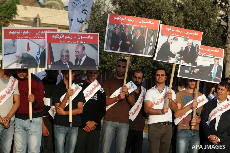 El-Ahrar party supporters carry placards and posters of Palestinian President Mahmoud Abbas with Israeli leaders during a demonstration in Gaza city on November 6, 2012. Protestors gathered to express their anger towards...