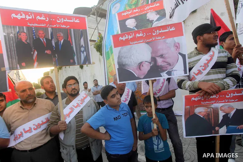 El-Ahrar party supporters carry placards and posters of Palestinian President Mahmoud Abbas with Israeli leaders during a demonstration in Gaza city on November 6, 2012. Protestors gathered to express their anger towards...