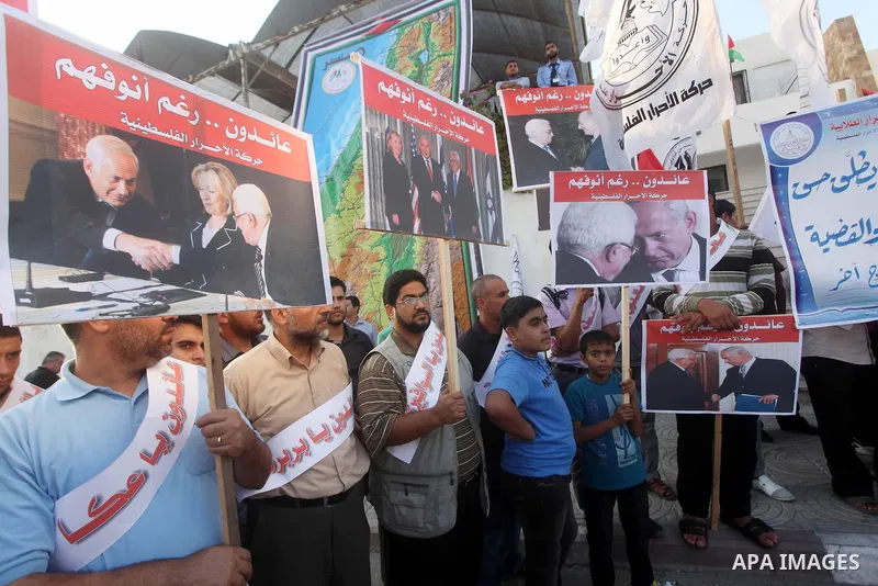 El-Ahrar party supporters carry placards and posters of Palestinian President Mahmoud Abbas with Israeli leaders during a demonstration in Gaza city on November 6, 2012. Protestors gathered to express their anger towards...