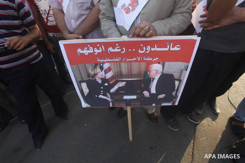 El-Ahrar party supporters carry placards and posters of Palestinian President Mahmoud Abbas with Israeli leaders during a demonstration in Gaza city on November 6, 2012. Protestors gathered to express their anger towards...