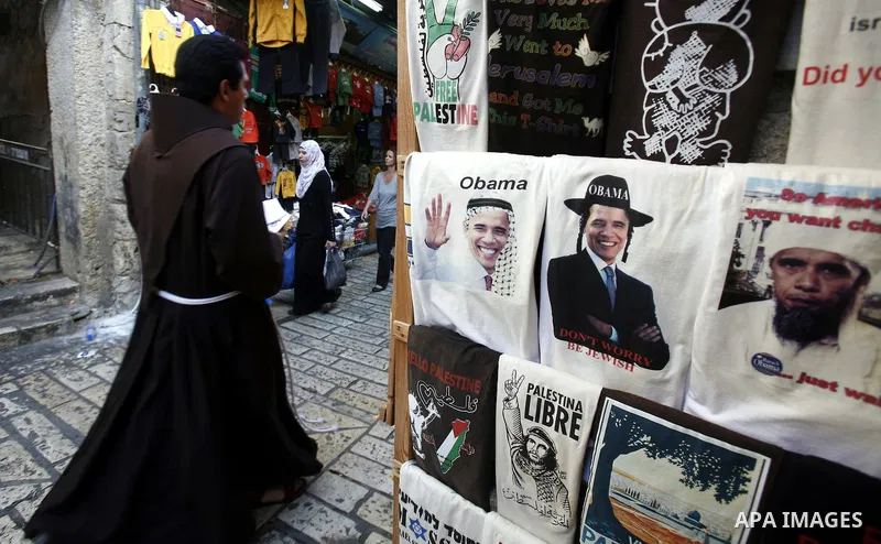 A Palestinian man walks pass posters of U.S. President Barack Obama during the first day of U.S. presidential elections, in Jerusalem on 06 November 2012. Recent polls show that U.S. President Barack Obama and Republican...