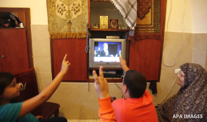 Palestinians watch T.V during the first day of U.S. presidential elections, in Jerusalem on 06 November 2012. Recent polls show that U.S. President Barack Obama and Republican presidential candidate Mitt Romney are in a...