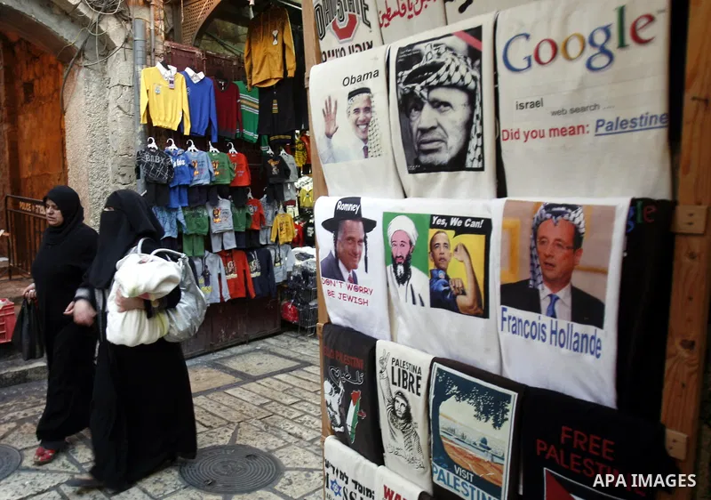 Palestinians walk pass posters of U.S. President Barack Obama during the first day of U.S. presidential elections, in Jerusalem on 06 November 2012. Recent polls show that U.S. President Barack Obama and Republican presi...