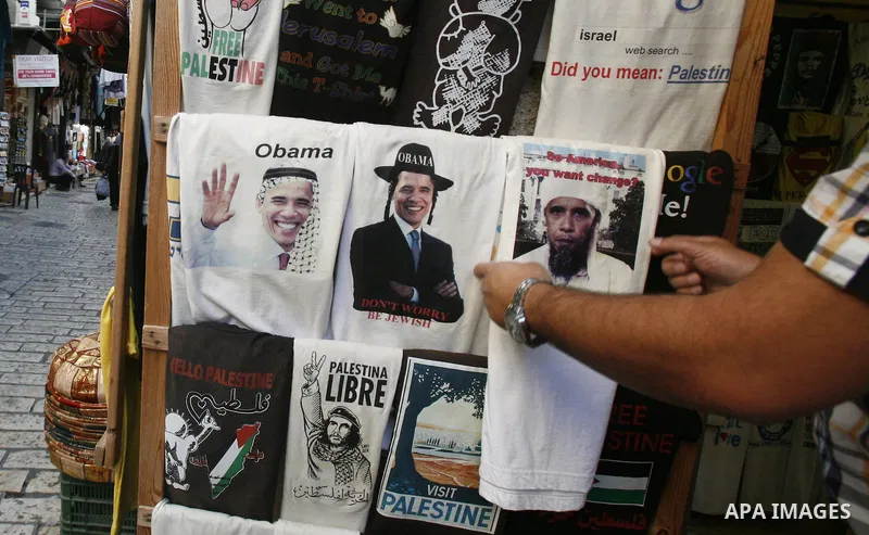 A Palestinian man pastes posters of U.S. President Barack Obama on his shopfront during the first day of U.S. presidential elections, in Jerusalem on 06 November 2012. Recent polls show that U.S. President Barack Obama a...