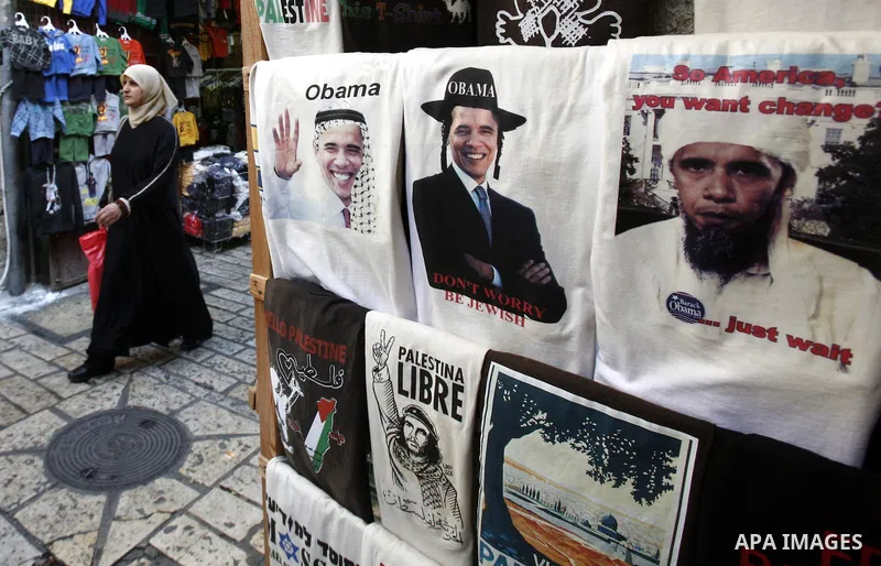 A Palestinian woman walks pass posters of U.S. President Barack Obama during the first day of U.S. presidential elections, in Jerusalem on 06 November 2012. Recent polls show that U.S. President Barack Obama and Republic...
