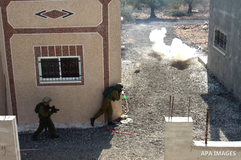 Israeli soldiers fire tear gas at Palestinians during demolition a Palestinian house by Israeli bulldozers in the village of Haris near Salfit southern the West Bank city Of Nablus on November 7, 2012. Demolition of Pale...