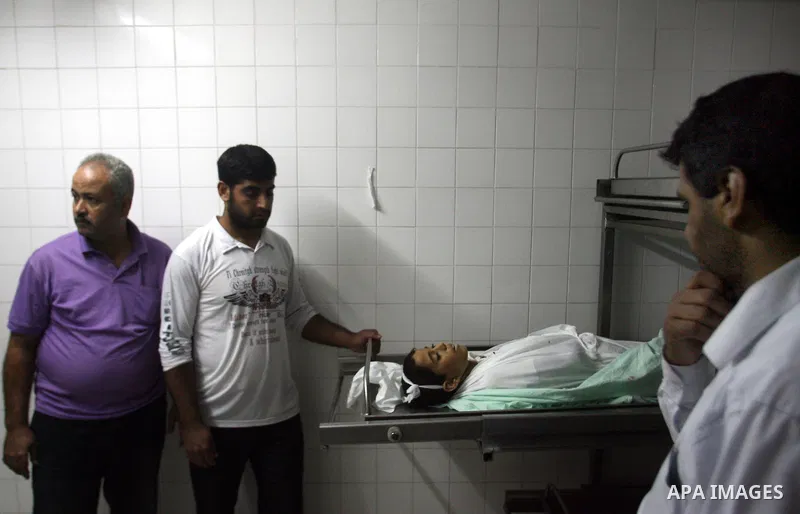Palestinians look at the body of Ahmed Abu Dagah, who was killed by gunfire from Israeli forces, at the morgue of a hospital in Khan Younis in the southern Gaza Strip November 8, 2012. Gunfire from Israeli forces killed...