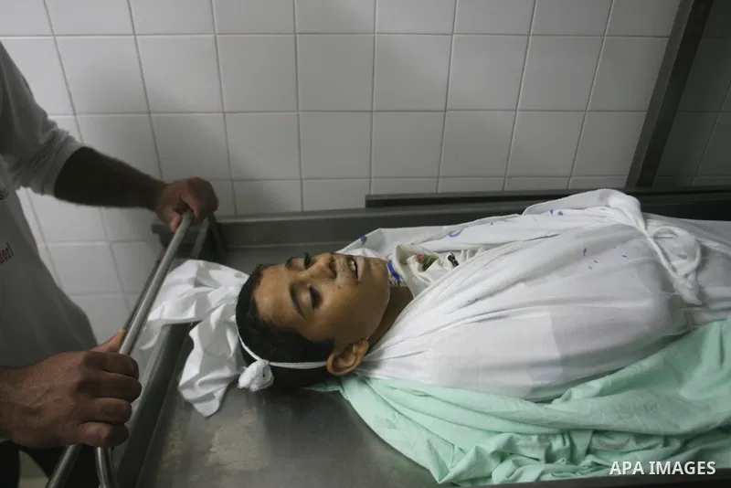 Palestinians look at the body of Ahmed Abu Dagah, who was killed by gunfire from Israeli forces, at the morgue of a hospital in Khan Younis in the southern Gaza Strip November 8, 2012. Gunfire from Israeli forces killed...
