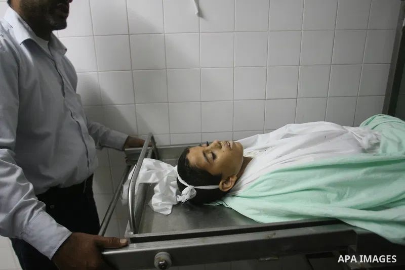 Palestinians look at the body of Ahmed Abu Dagah, who was killed by gunfire from Israeli forces, at the morgue of a hospital in Khan Younis in the southern Gaza Strip November 8, 2012. Gunfire from Israeli forces killed...