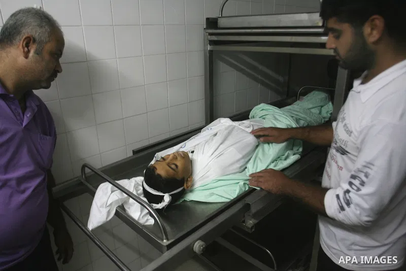 Palestinians look at the body of Ahmed Abu Dagah, who was killed by gunfire from Israeli forces, at the morgue of a hospital in Khan Younis in the southern Gaza Strip November 8, 2012. Gunfire from Israeli forces killed...