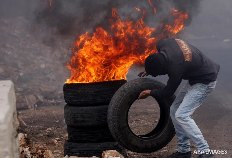 A Palestinian protester burns tires during clashes following a demonstration against the expropriation of Palestinian land by Israel in the village of Kfar Qaddum, near the occupied West Bank city of Nablus on November 0...