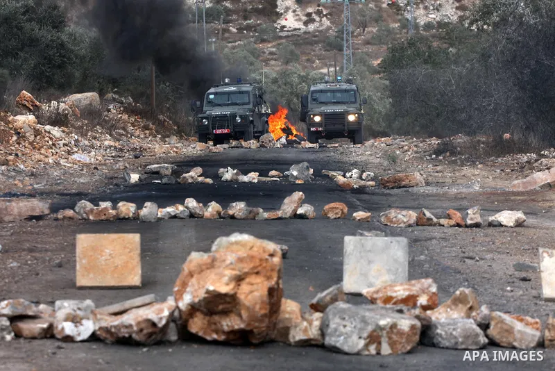 Israeli military vehicles stand ready during clashes with Palestinian protesters following a demonstration against the expropriation of Palestinian land by Israel in the village of Kfar Qaddum, near the occupied West Ban...
