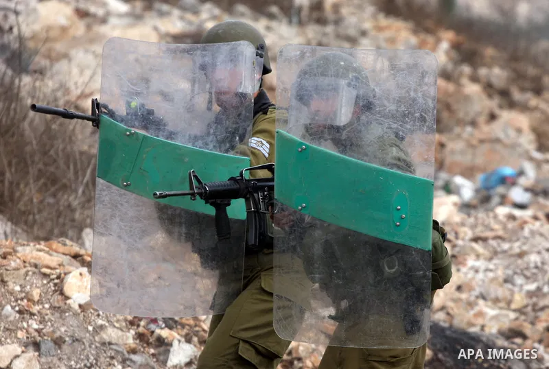 Israeli soldiers shoot towards Palestinian protesters during clashes following a demonstration against the expropriation of Palestinian land by Israel in the village of Kfar Qaddum, near the occupied West Bank city of Na...