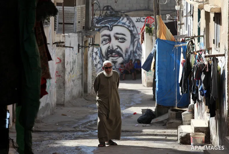A Palestinian man walks in front of a mural of the Palestinian Leader Yasser Arafat in Gaza City, on November 10, 2012. "The Eighth anniversary of the departure of the founding leader". Photo by Majdi Fathi