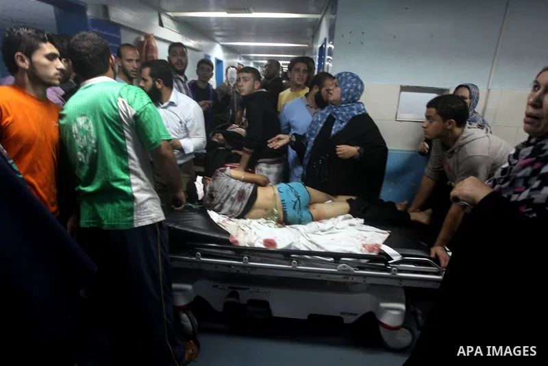 A wounded Palestinian is wheeled on a stretcher at a hospital in Gaza City following Israeli shelling November 10, 2012. Israeli tank shells killed at least two Palestinians and wounded 20 in the Gaza Strip on Saturday a...