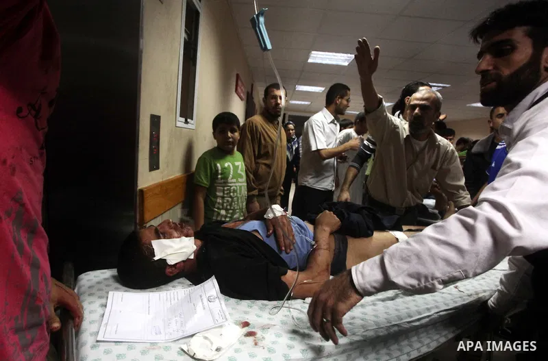 A wounded Palestinian is wheeled on a stretcher at a hospital in Gaza City following Israeli shelling November 10, 2012. Israeli tank shells killed at least two Palestinians and wounded 20 in the Gaza Strip on Saturday a...