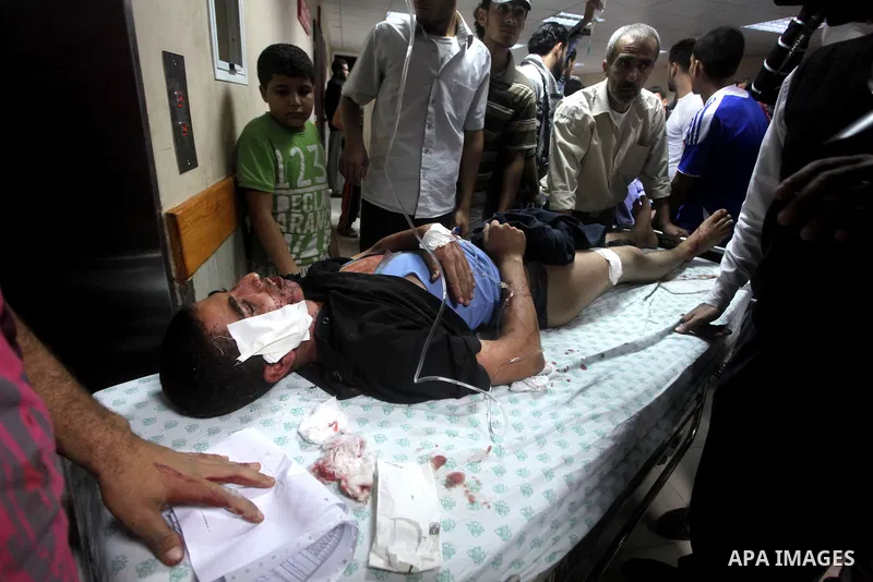 A wounded Palestinian is wheeled on a stretcher at a hospital in Gaza City following Israeli shelling November 10, 2012. Israeli tank shells killed at least two Palestinians and wounded 20 in the Gaza Strip on Saturday a...