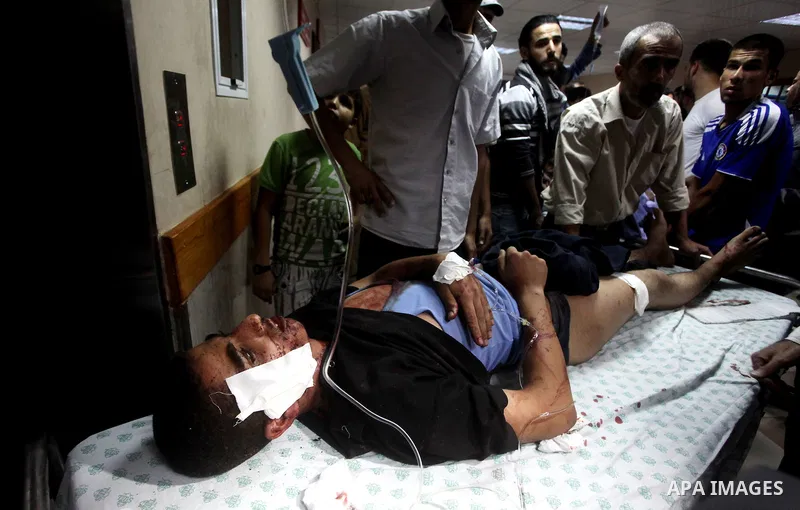 A wounded Palestinian is wheeled on a stretcher at a hospital in Gaza City following Israeli shelling November 10, 2012. Israeli tank shells killed at least two Palestinians and wounded 20 in the Gaza Strip on Saturday a...