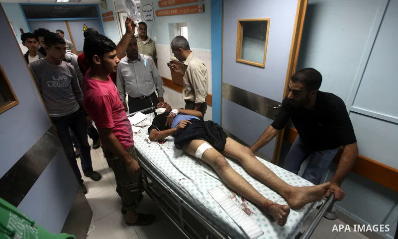 A wounded Palestinian is wheeled on a stretcher at a hospital in Gaza City following Israeli shelling November 10, 2012. Israeli tank shells killed at least two Palestinians and wounded 20 in the Gaza Strip on Saturday a...