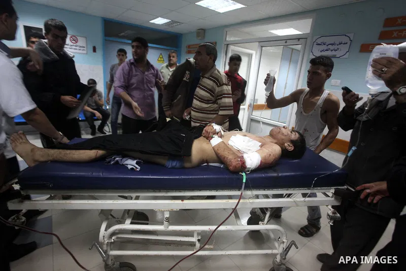 A wounded Palestinian is wheeled on a stretcher at a hospital in Gaza City following Israeli shelling November 10, 2012. Israeli tank shells killed at least two Palestinians and wounded 20 in the Gaza Strip on Saturday a...
