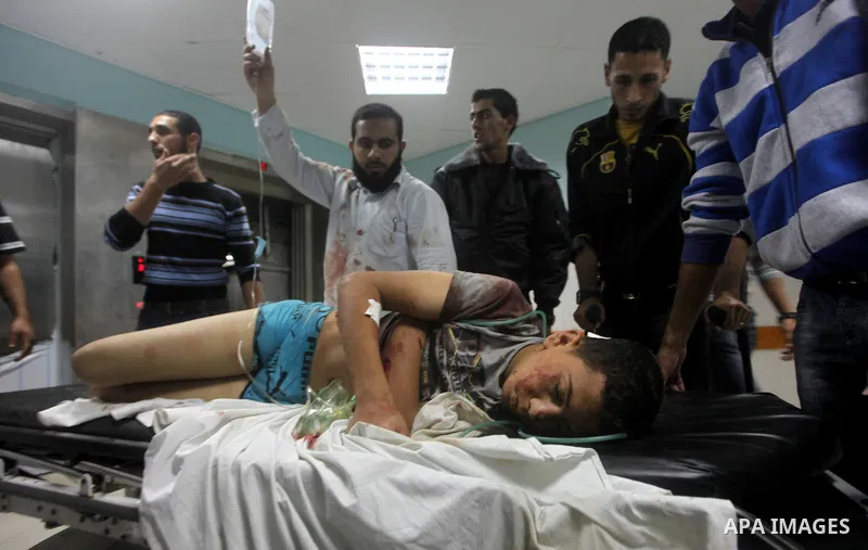 A wounded Palestinian is wheeled on a stretcher at a hospital in Gaza City following Israeli shelling November 10, 2012. Israeli tank shells killed at least two Palestinians and wounded 20 in the Gaza Strip on Saturday a...