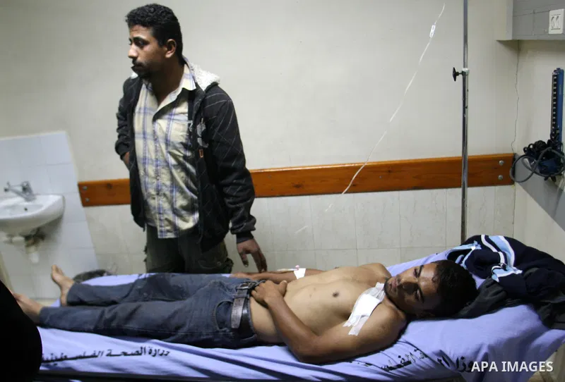 Palestinians lie on stretchers as they receive treatment at a hospital in Khan Yunis, southern Gaza Strip, after being wounded in Israeli shelling as clashes erupted along the border on November 10, 2012. Two Palestinian...