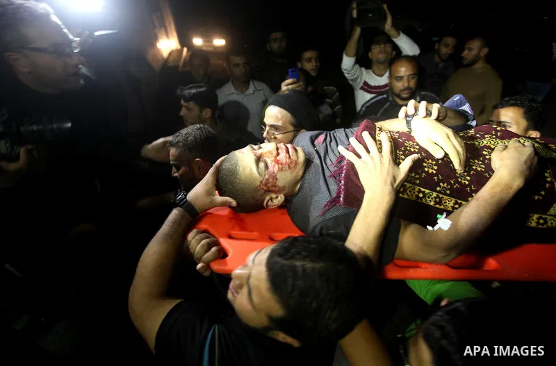 Palestinians youth carry the body at al-Shifa hospital morgue in Gaza City following Israeli shelling that killed several people as clashes erupted along the border on November 10, 2012. Israeli artillery fire killed sev...