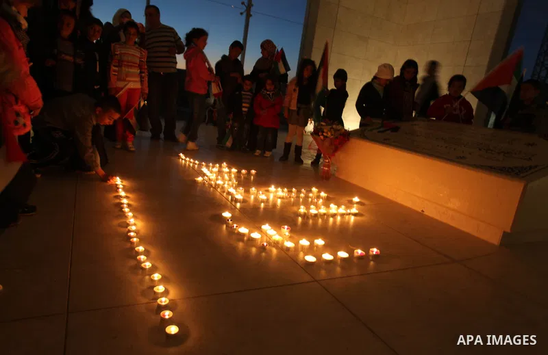 Palestinians gather to light candles at the mausoleum of their late leader Yasser Arafat in the West Bank city of Ramallah, on November 10, 2012, ahead of a ceremony marking the eighth anniversary of this death. The Pale...