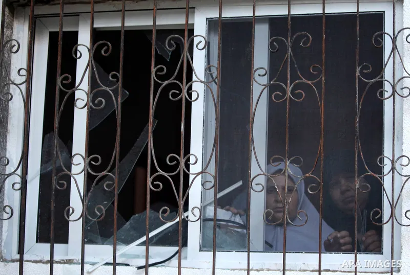 A Palestinian woman looks at what Palestinians say is a house damaged in an Israeli air strike in Gaza City November 11, 2012. An Israeli air strike killed a Palestinian militant in the Hamas-governed Gaza Strip on Sunda...