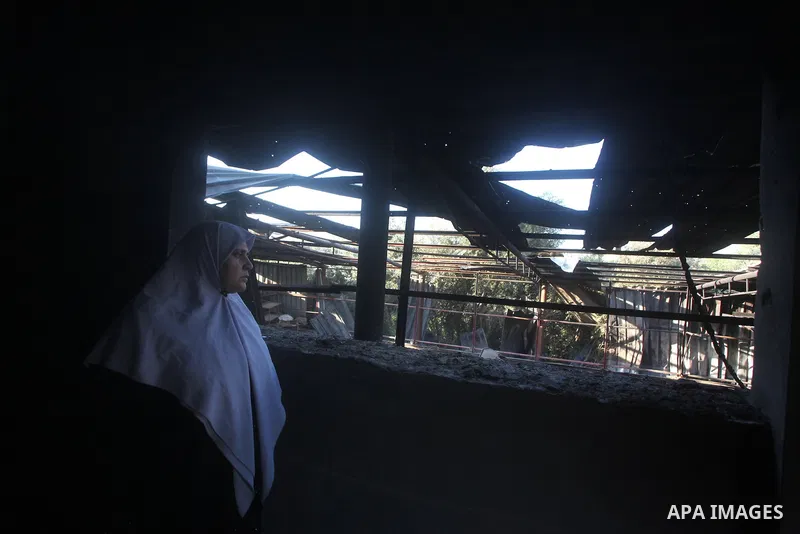 A Palestinian woman looks at what Palestinians say is a house damaged in an Israeli air strike in Gaza City November 11, 2012. An Israeli air strike killed a Palestinian militant in the Hamas-governed Gaza Strip on Sunda...