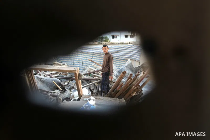 A boy looks at what Palestinians say is a house damaged in an Israeli air strike in Gaza City November 11, 2012. An Israeli air strike killed a Palestinian militant in the Hamas-governed Gaza Strip on Sunday as a surge i...