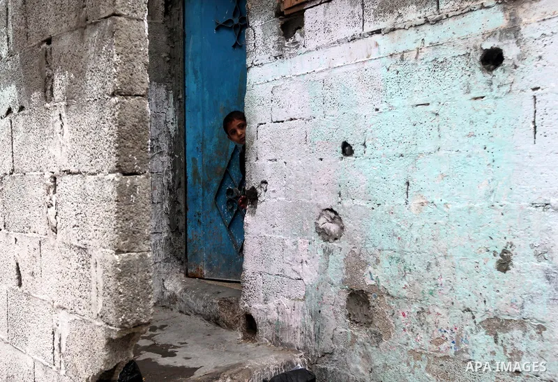 Palestinian children look through a door at the funeral at the Shati refugee camp in Gaza City, Sunday, Nov. 11, 2012. Hostilities along the Gaza-Israel border escalated sharply over the weekend, with bombardments from G...