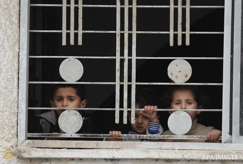 Palestinian children look through a window during a funeral in Gaza City on November 11, 2012 , the day after he was killed in Israeli shelling as clashes erupted along the Isreali-Gaza Strip border. The flare-up was one...