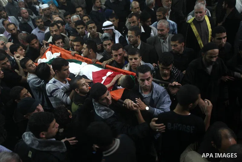 Mourners carry the body of killed Palestinian civilian Ahmad Dardasawy, 18, during his funeral in Gaza City on November 11, 2012 , the day after he was killed in Israeli shelling as clashes erupted along the Isreali-Gaza...