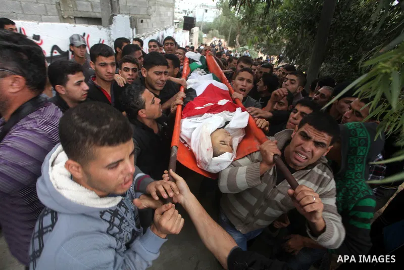 Mourners carry the body of killed Palestinian civilian Ahmad Dardasawy, 18, during his funeral in Gaza City on November 11, 2012 , the day after he was killed in Israeli shelling as clashes erupted along the Isreali-Gaza...