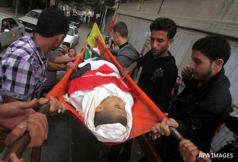 Mourners carry the body of killed Palestinian civilian Ahmad Dardasawy, 18, during his funeral in Gaza City on November 11, 2012 , the day after he was killed in Israeli shelling as clashes erupted along the Isreali-Gaza...